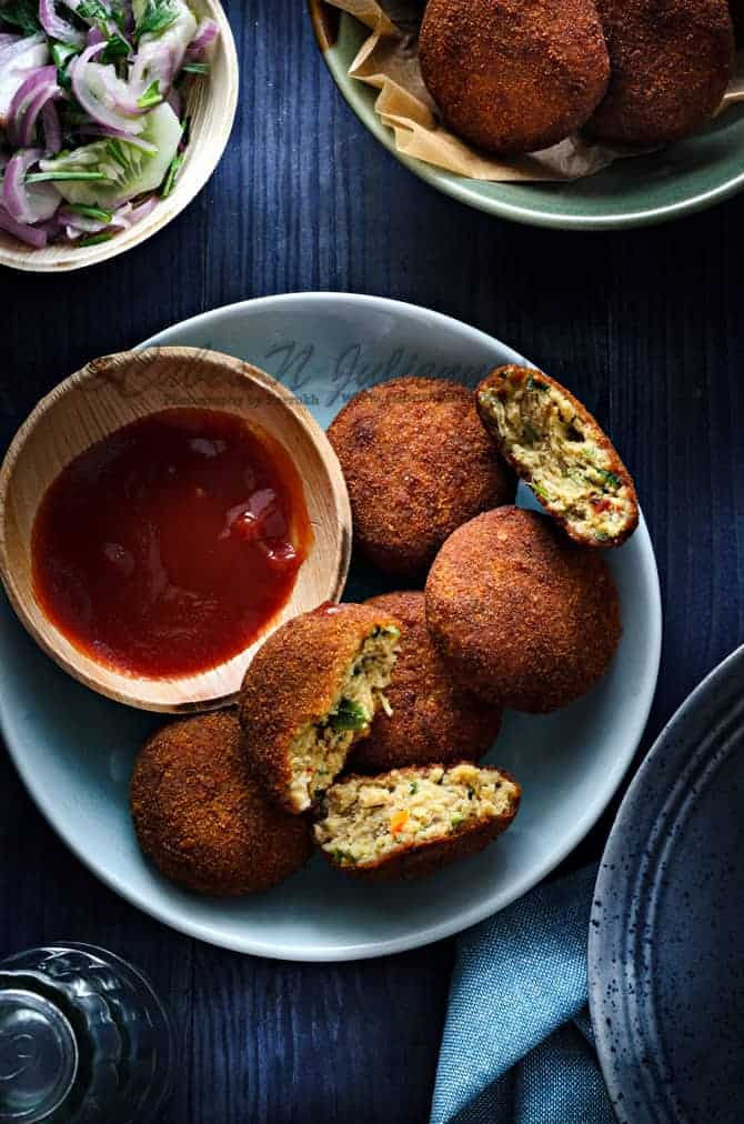 Crispy chicken cutlets on a blue plate with sauce on the side