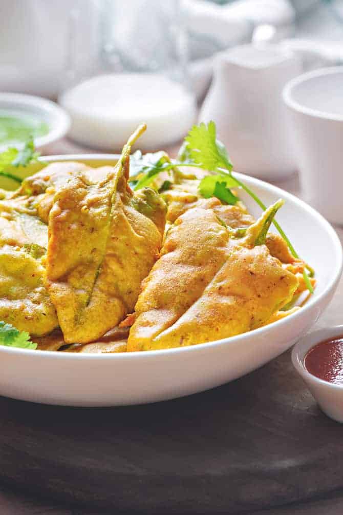 close up shot of palak pakoda in white bowl.