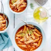 Instant Pot Tomato pasta soup served in 3 blue bowls with cheese on the side