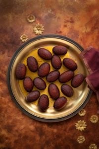 Overhead shot of Milk Powder Gulab Jamun served on traditional brass plate