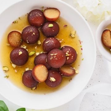 Khoya Gulab Jamun coked in saffron flavoured sugar syrup and served in large white bowl