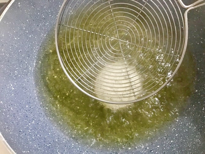 pressing the golgappa puri with ladle to puff it up while frying