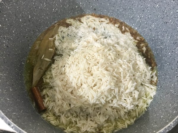Soaked and strained rice added in pot to make jeera rice recipe