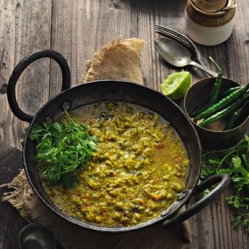 Spicy Matar Ka Nimona in traditional iron kadai with rice on the side.