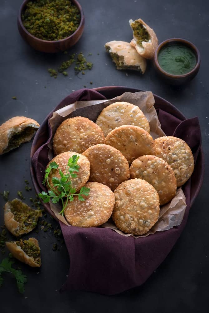 Matar Kachori served in large wooden bowl with green chutney on the side.