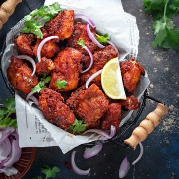 Crisp Chicken Fry kabab served in a basket, onions and lemon on the side