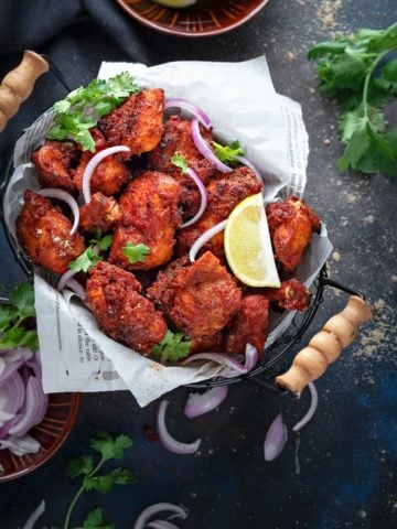 Crisp Chicken Fry kabab served in a basket, onions and lemon on the side