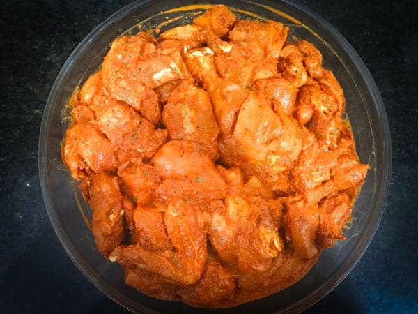 Masala (spices) coated chicken in a large bowl