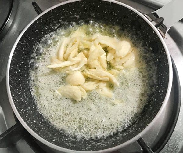 Crushed garlic added in a pan with melted butter