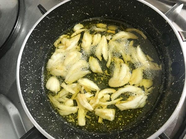 Crushed garlic cooking a butter in pan