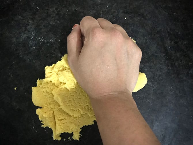 Kneading the dough ball with the heels of the palm, just before shaping them