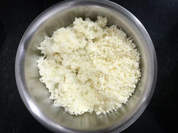 Grated paneer and boiled and grated potato added in a bowl