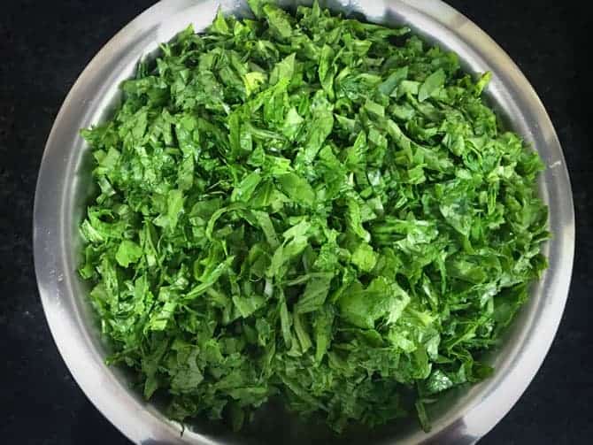 Chopped mustard leaves, bathua and spinach greens in a large bowl