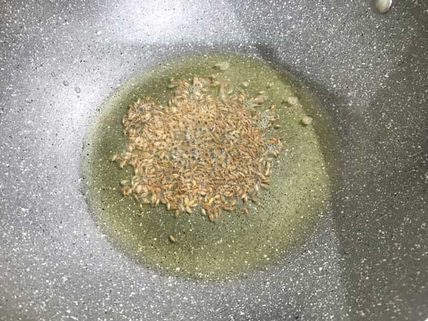 Cumin seeds added in pan with hot oil to make matar ka nimona recipe