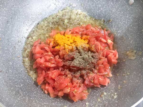Chopped tomato, turmeric and black pepper powder added in pan