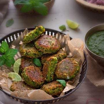 Crisp Paneer Matar Kabab served in a traditional brass bowl with green chutney on the side.