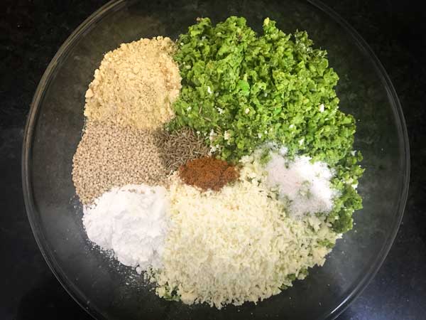 Paneer, coarse peas mixture, seeds, spice powders, salt, and flours added in a bowl