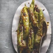 Bharwa mirchi fry served on oval metal plate.