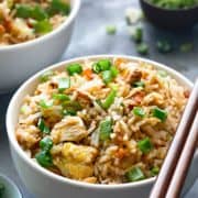 Close up shot of best chicken fried rice in white bowl with a pair of chopsticks