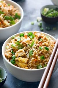 Close up shot of best chicken fried rice in white bowl with a pair of chopsticks