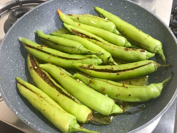 Bharwa mirchi or stuffed green chillies added in pan