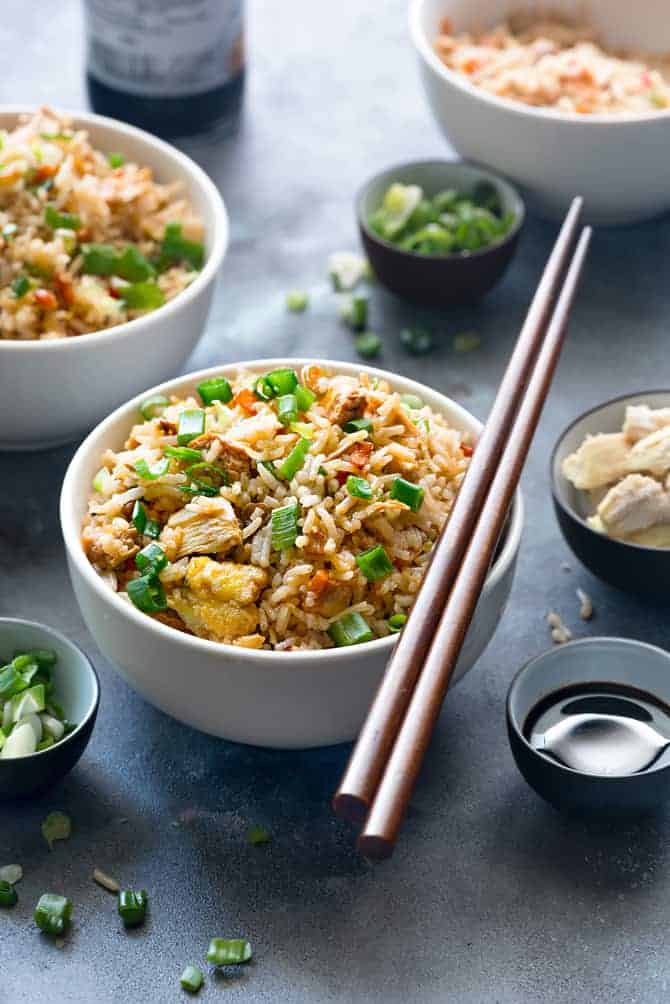 Authentic Chicken fried rice served in white bowl with a pair of chopsticks.