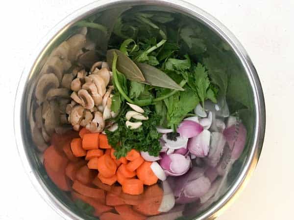 Cut Veggies, mushroom, herbs, spices added in instant pot to make vegetable stock recipe