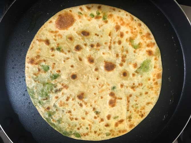 Ghee applied on matar paratha and cooked