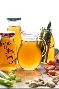 Homemade Vegetable Stock in glass pitcher and glass bottles.