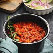 Andhra style tomato chutney recipe or Thakkali chutney in pan with salad at the back.