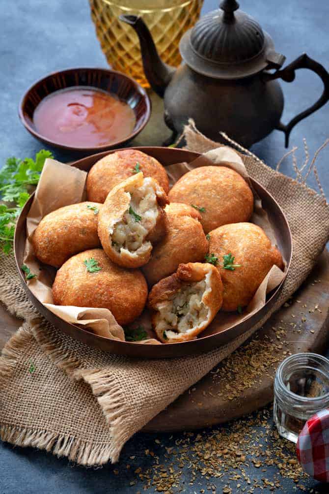 Crispy aloo bread roll served on copper plate along with ketchup on the side