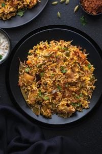 Close up shot of instant pot vegetable biryani served in black plate.