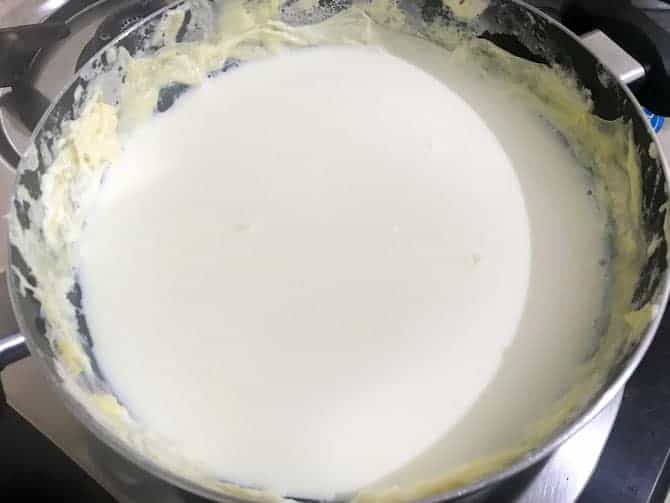 Reduced milk simmering with thick cream or malai on the sides of the pan.