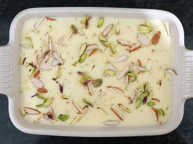 Thickened milk cream and dry fruits topped on soaked bread for Delhi style Shahi Tukda