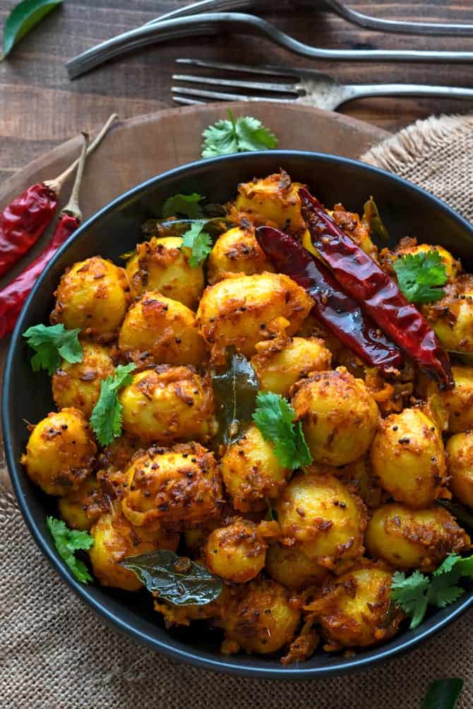 Close up shot of spicy roast baby potatoes served in black plate