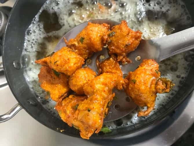 Crisp fried chicken pakora on ladle.