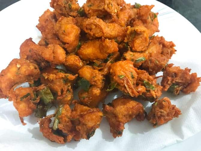 Fried chicken pakora on absorbent paper on plate, ready to serve.