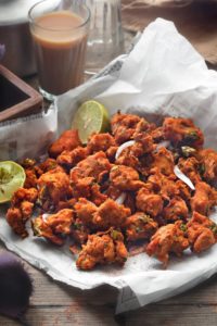 Close up shot of chicken pakora on parchment lined paper.