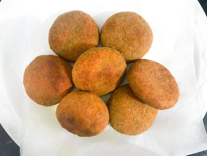 Crisp fried veg cutlets on absorbent towel on plate.