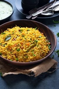 Semiya upma or vegetable vermicelli upma in wooden bowl, spoons and chutney at the back.