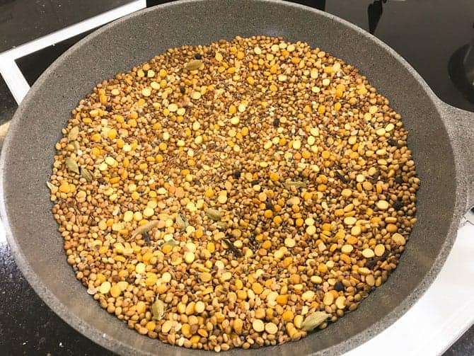 Chana dal, urad dal and whole spices dry roasting pan for the making of sambar powder recipe.