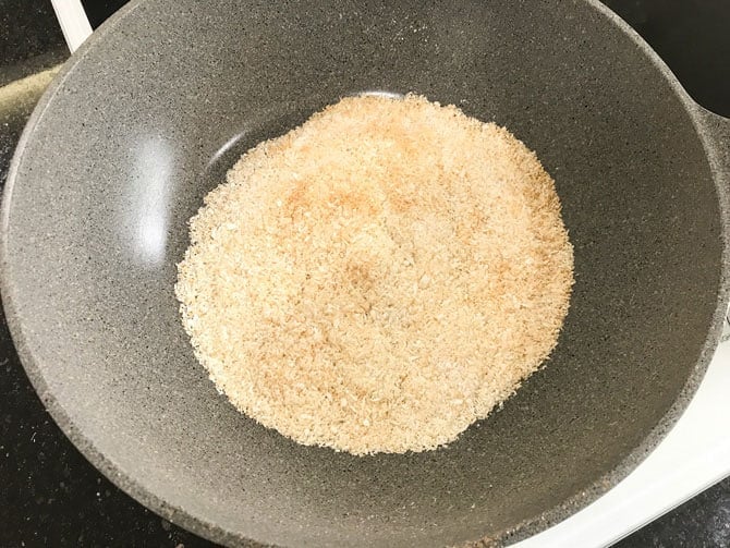 Dry roasting coconut powder in pan.