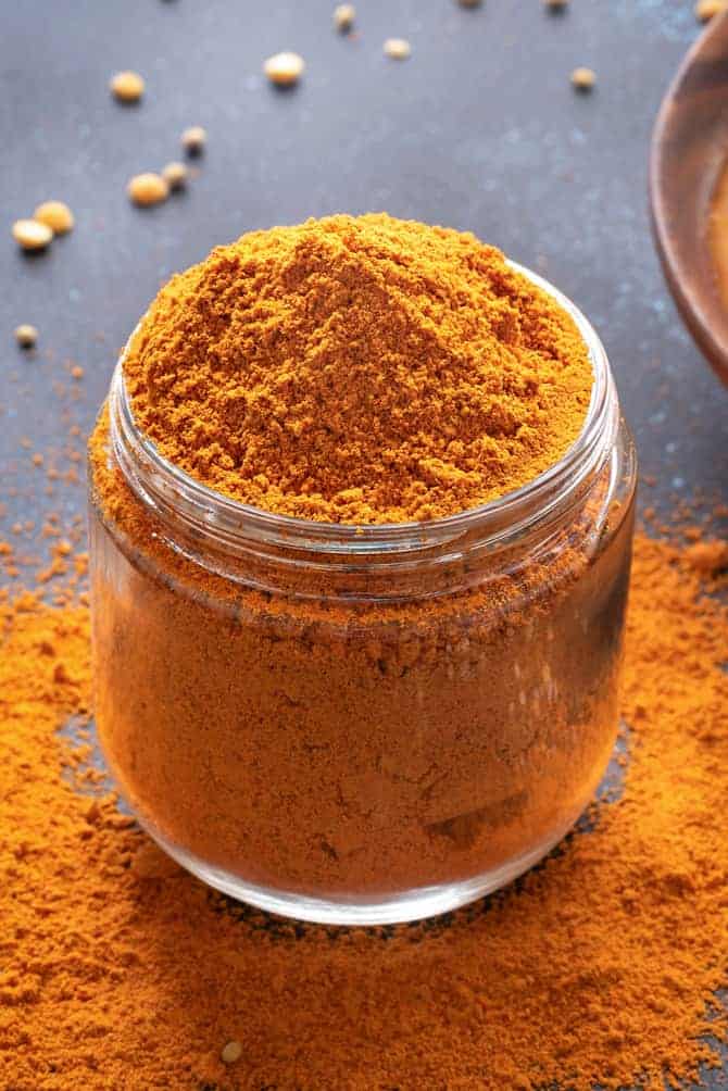 Close-up shot of homemade sambar powder or sambar masala in a glass jar.