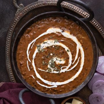 Close up shot of restaurant style Punjabi dal makhani or kali dal served in traditional kadhai.