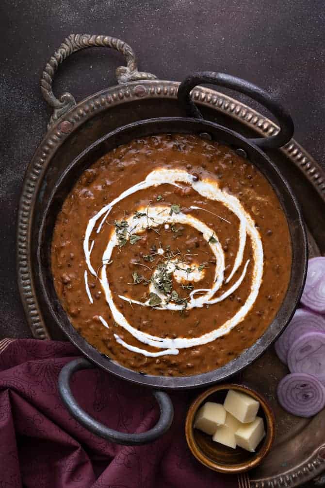 Close up shot of restaurant style Punjabi dal makhani or kali dal served in traditional kadhai.