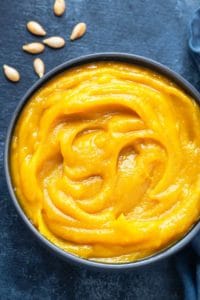 Close up shot of homemade pumpkin puree in blue bowl.