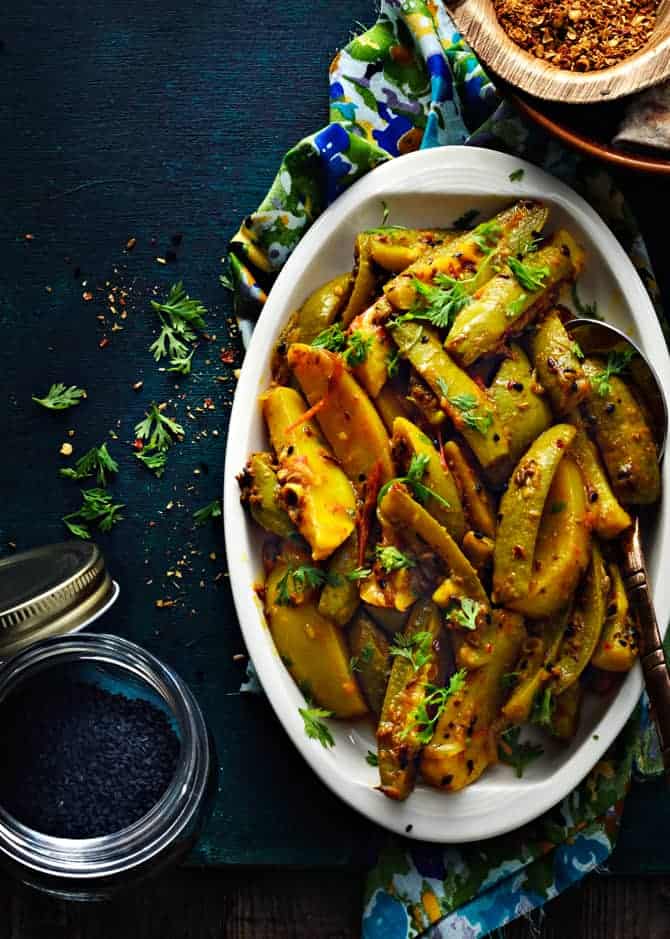 Close up shot of aloo parwal sabzi on white oval plate.