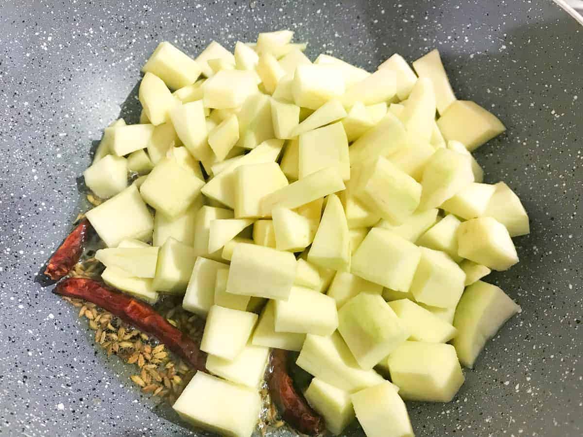 Raw mango cubes added in pan.