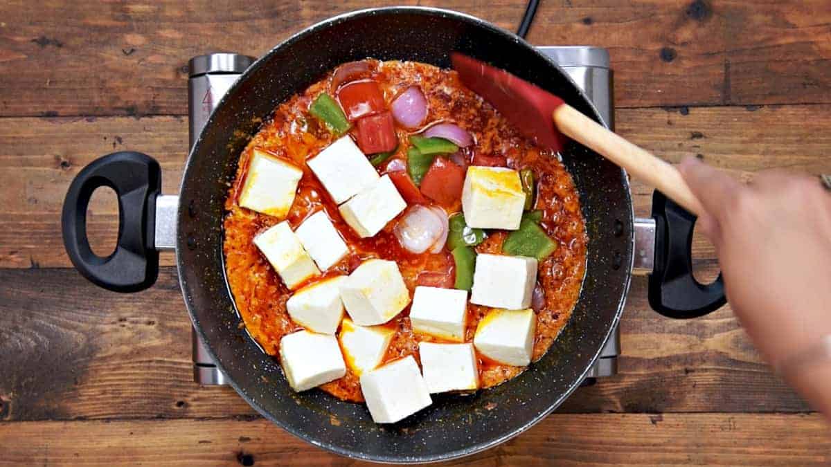 Paneer, roasted onion, tomato and capsicum added in pan.