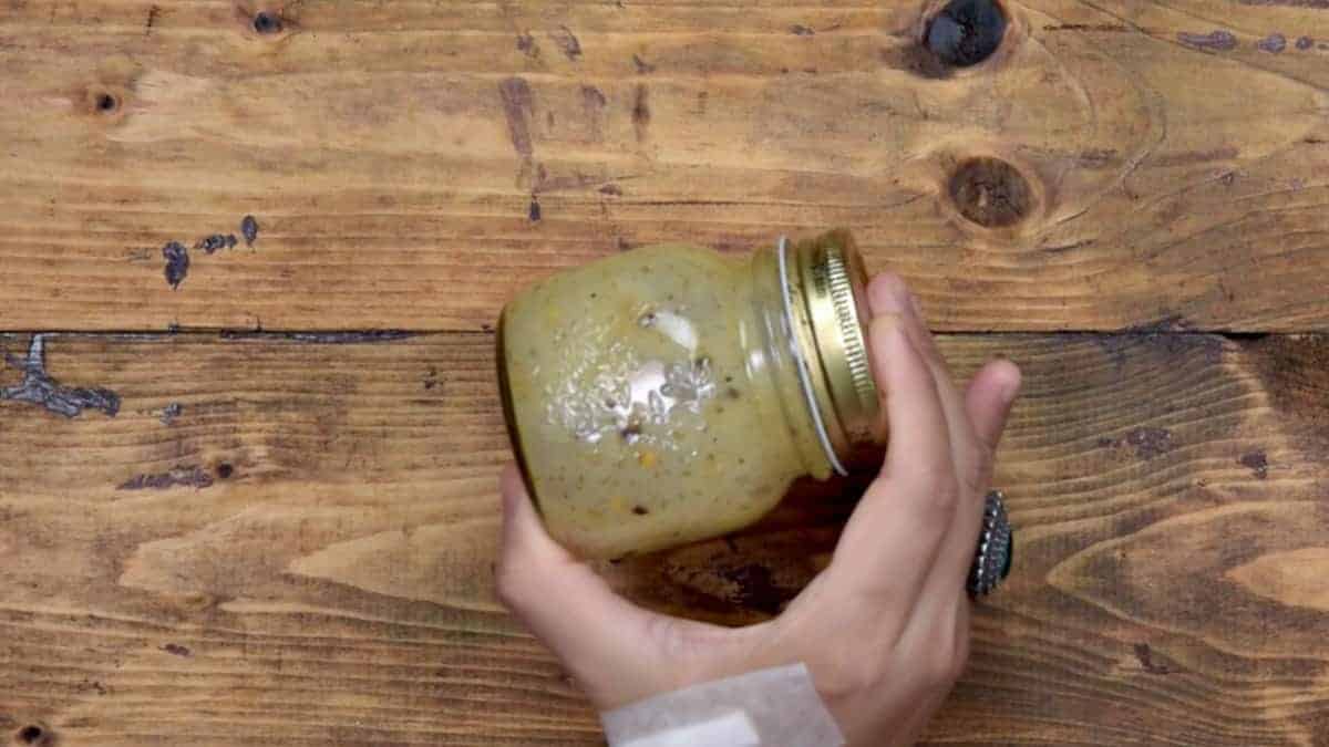 Mixing the lemon dressing ingredients in glass jar.